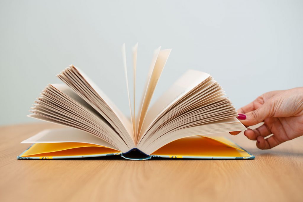 Picture of an open book with a hand